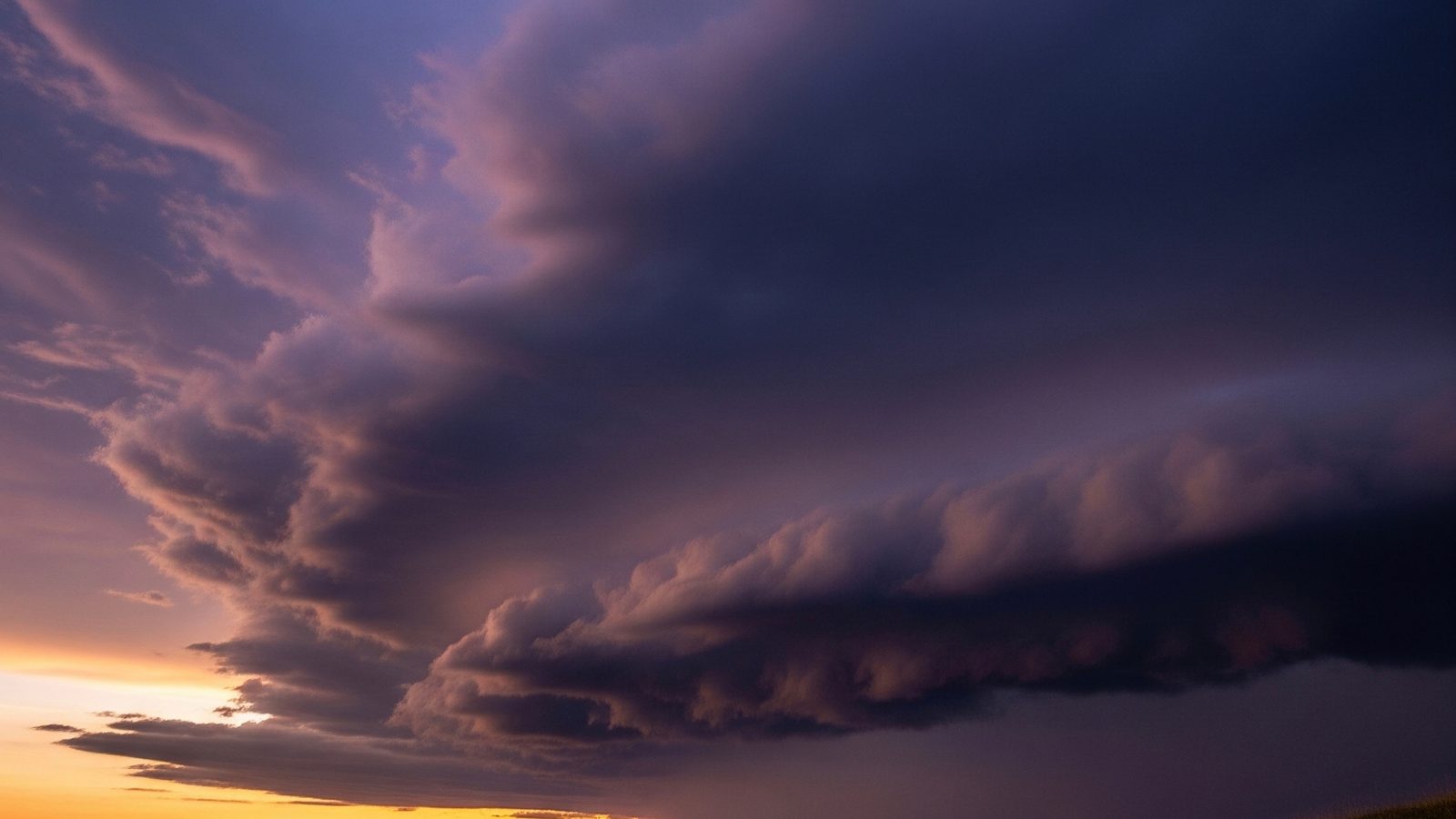 A heavy shelf cloud building at dusk